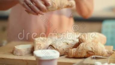 女人把牛角面包灌入咖啡。 布鲁内特享受<strong>早餐时间</strong>。